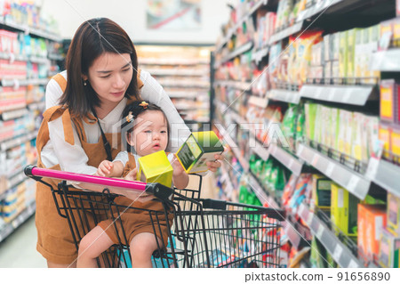 Asian mother and her daughter buying food at huge supermarket , Baby sit in trolley, Family shopping concept. 91656890