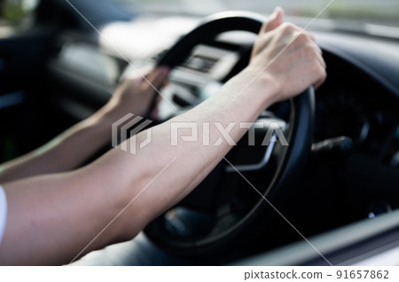 Driving drive at the hands of a man holding the steering wheel 91657862