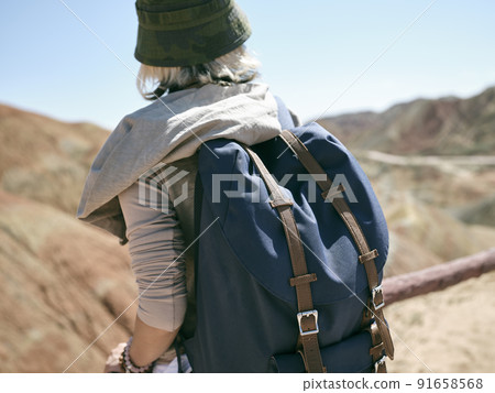rear view of an asian woman female tourist backpacker looking at the yardang landforms in national geological park rear view of an asian woman female tourist backpacker looking at the yardang landforms in national geological park 91658568