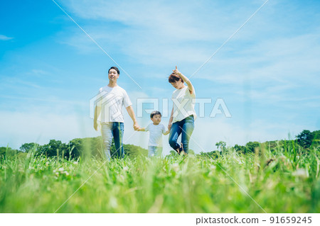 三個父母和孩子手牽著手走在陽光明媚的綠地裡 三個父母和孩子手牽著手走在陽光明媚的綠地裡 91659245