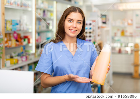 Pharmacist showing bottle with haircare product 91659890