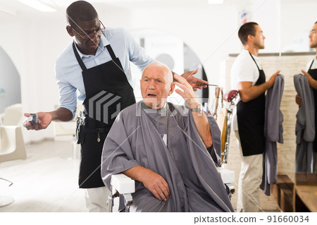 Senior man unpleasantly surprised by haircut from African hairdresser 91660034