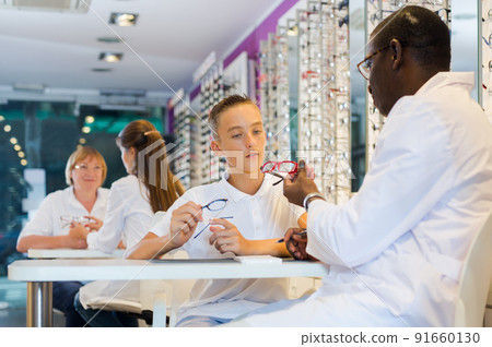 Teenager looking for glasses with African-American optician 91660130