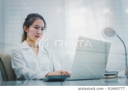 Business woman sitting and using laptop in office. 91660777