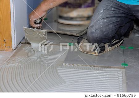 Before adding tiles to a bathroom floor, it is necessary to spread wet mortar 91660789