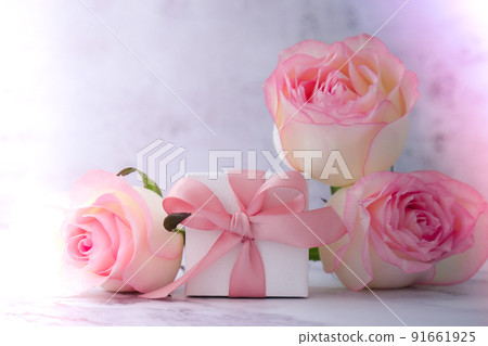 Gift box with tied ribbon bow pink roses on pink background. Greeting card. Present for springtime holidays Copy space for text. Gift box with tied ribbon bow pink roses on pink background. Greeting card. Present for springtime holidays Copy space for text. 91661925