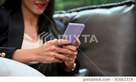 Asian woman or businesswoman relaxes on the sofa and uses a smartphone 91662319