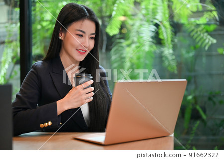 Elegant Asian businesswoman remote working in the office shop, using laptop. Elegant Asian businesswoman remote working in the office shop, using laptop. 91662322