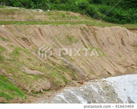 Permanent slope protection with grass using the hydroseed method. The grass is used to stabilize the slope structure and prevent slope erosion. Effective and less maintenance.  91663469