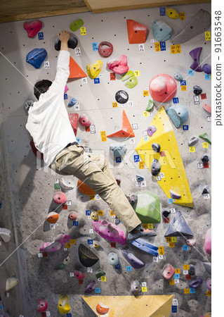 Young man bouldering 91663548