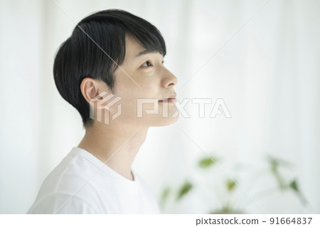 Profile of a young man in a white T-shirt Men's beauty image Portrait looking at the camera 91664837