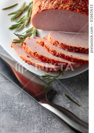Smoked ham with rosemary and kitchen knife. 91665633