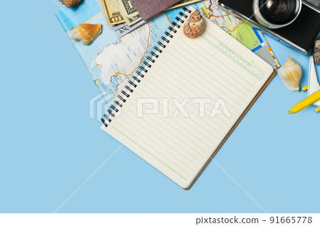 Blank noyebook with vintage camera, old map on blue background Blank noyebook with vintage camera, old map on blue background 91665778