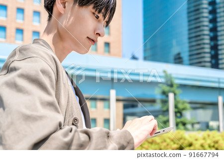 Looking up at a young office casual businessman with a tablet Looking up at a young office casual businessman with a tablet 91667794