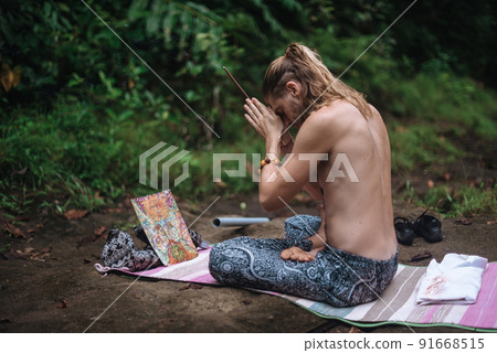 Yoga practice and meditation in nature. Man practicing near river 91668515