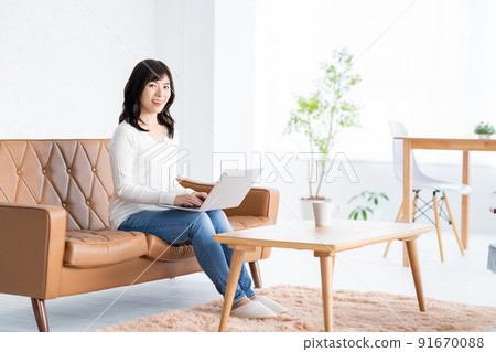 Women's living room PC telework lifestyle 91670088