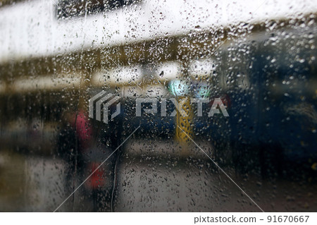 Blurred background of raindrops on glass against background of city Blurred background of raindrops on glass against background of city 91670667