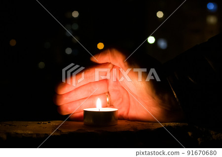 Palm closes the candle in the dark Palm closes the candle in the dark 91670680