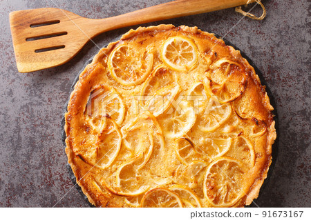 Lemon tart with delicate sweet and sour cream and pieces of fruit close-up in a plate. horizontal top view 91673167