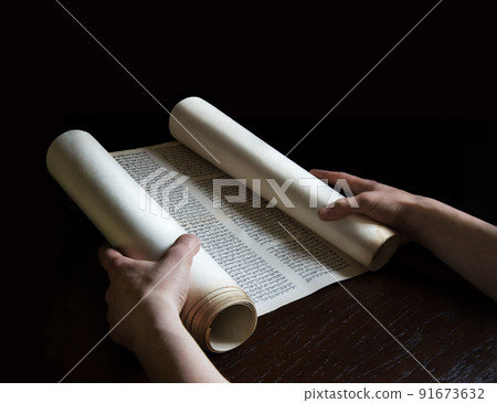 Hands holding an ancient scroll 91673632