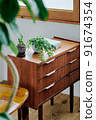 Cabinet under the window and green plants 91674354