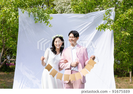 Korean Asian couple self small wedding concept in spring_holding decorative garland Korean Asian couple self small wedding concept in spring_holding decorative garland 91675889