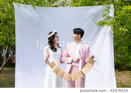 Korean Asian couple self small wedding concept in spring_holding decorative garland 91676028