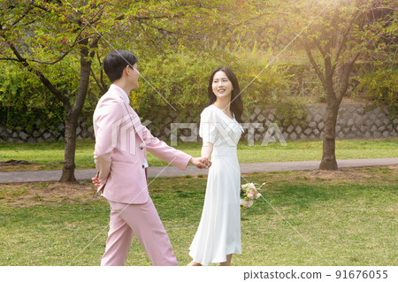 Korean Asian couple self small wedding concept in spring, talking a walk Korean Asian couple self small wedding concept in spring, talking a walk 91676055