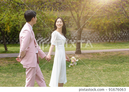 Korean Asian couple self small wedding concept in spring, talking a walk Korean Asian couple self small wedding concept in spring, talking a walk 91676063
