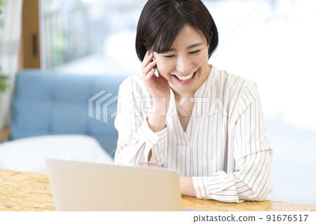A young woman who teleworks a woman who makes a video call A young woman who teleworks a woman who makes a video call 91676517