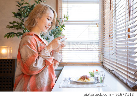 Young woman taking a picture of a meal on her smartphone Young woman taking a picture of a meal on her smartphone 91677118