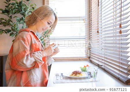 Young woman taking a picture of a meal on her smartphone Young woman taking a picture of a meal on her smartphone 91677121