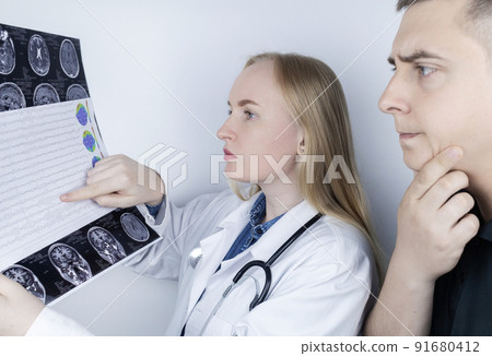 Epileptologist examines patient MRI and electroencephalogram. Concept treating epilepsy and helping people who suffer from this disease. Neurologist at work. Pathology of the brain. Seizure activity 91680412