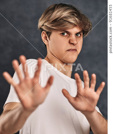young man expressing negativity on gray background. 91681455