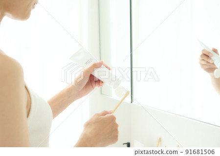 Woman brushing teeth in the bathroom 91681506