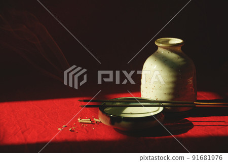 Light and shadows cast on a porcelain container and incense sticks showing the concept of meditation, mindfulness and mental wellbeing Light and shadows cast on a porcelain container and incense sticks showing the concept of meditation, mindfulness and mental wellbeing 91681976