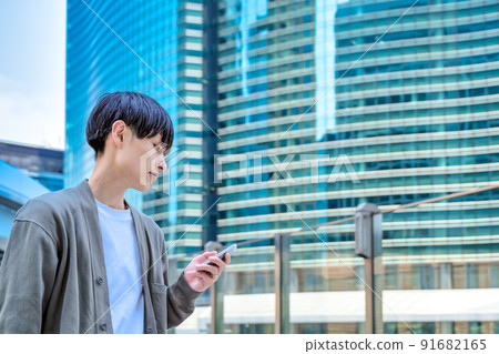 Office casual young businessman who operates a smartphone Smartphone Office casual young businessman who operates a smartphone Smartphone 91682165