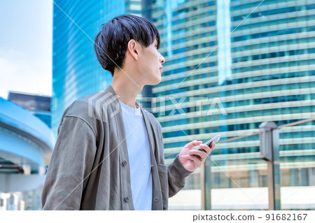Office casual young businessman who operates a smartphone Smartphone Office casual young businessman who operates a smartphone Smartphone 91682167