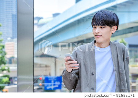 Office casual young businessman who operates a smartphone Smartphone Office casual young businessman who operates a smartphone Smartphone 91682171