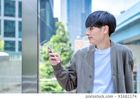 Office casual young businessman who operates a smartphone Smartphone Office casual young businessman who operates a smartphone Smartphone 91682174