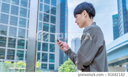 Office casual young businessman who operates a smartphone Smartphone Office casual young businessman who operates a smartphone Smartphone 91682182