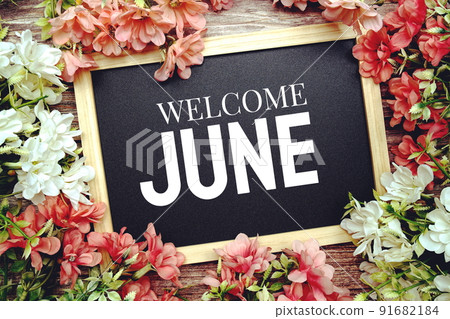 Welcome June typography text written on wooden blackboard with flower bouquet decorate on wooden background 91682184