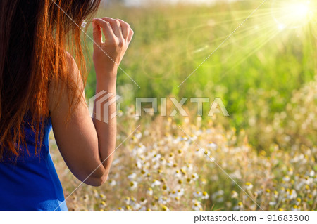 Woman touching nature, woman among chamomile flowers. 91683300