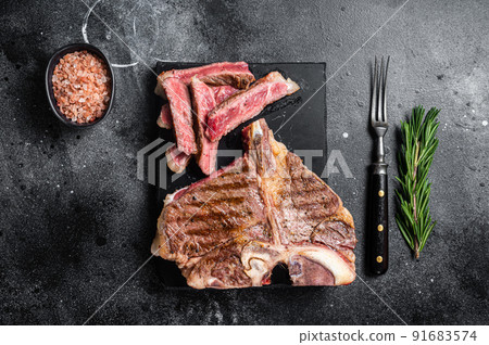 T bone grilled beef meat Steak, cooked Porterhouse on a marble board. Black background. Top view T bone grilled beef meat Steak, cooked Porterhouse on a marble board. Black background. Top view 91683574