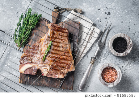 Grilled t-bone porterhouse beef meat Steak on a grill with spices. Gray background. Top view 91683583