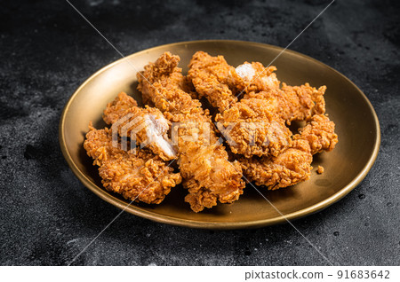 Breaded chicken strips, breast fillet meat on a plate. Black backgrund. Top view 91683642