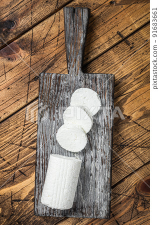 Sliced Soft Goat cheese on a cutting board. Wooden background. Top view Sliced Soft Goat cheese on a cutting board. Wooden background. Top view 91683661
