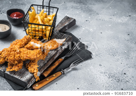 Breaded chicken strips with french fries and ketchup. Gray backgrund. Top view. Copy space 91683710