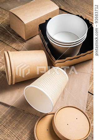 Disposable paper tableware. Eco friendly Recycling set of paper cups, dishes, bag, fast food containers and cutlery. Wooden background. Top view. Copy space Disposable paper tableware. Eco friendly Recycling set of paper cups, dishes, bag, fast food containers and cutlery. Wooden background. Top view. Copy space 91683712