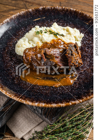 Beef cheeks stewed in red wine sauce with mashed potatoes. Wooden background. Top view 91683772